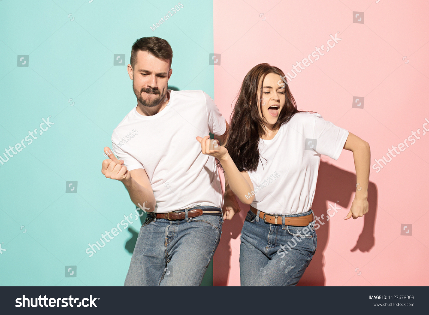 Et par unge sjove og glade mand og kvinde dansende hip-hop i studiet på blå og pink trendy farve baggrund. Menneskelige følelser, ungdom, kærlighed og livsstil koncept Stock-foto