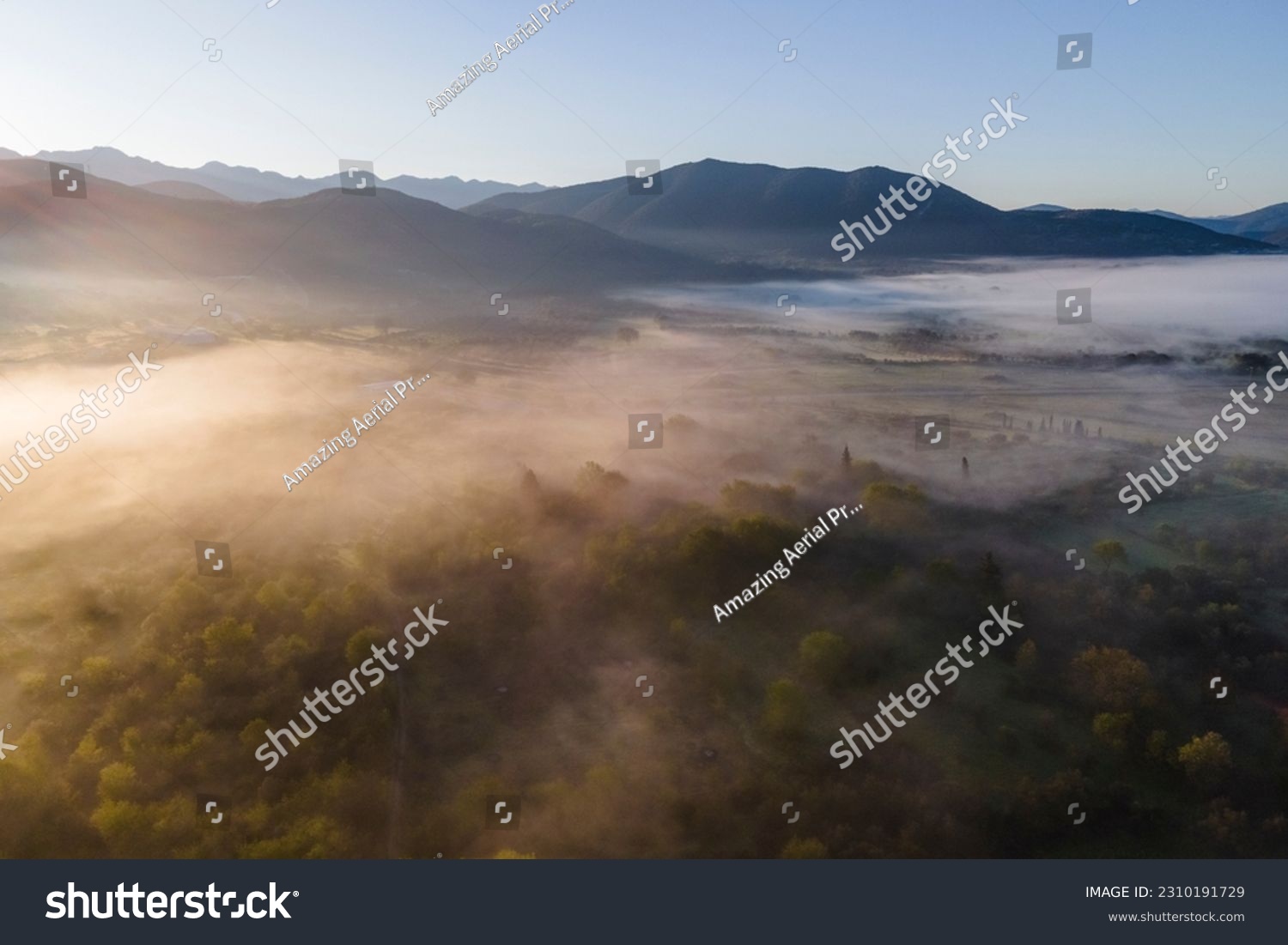 Aerial view of a valley with fog in early morning mist among mountains in Psaka, Epirus, Greece. Stock-foto
