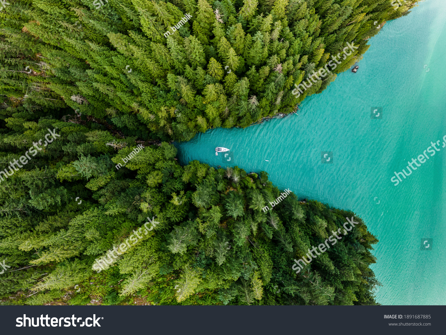 Boat moored in a cove with green forests all around aerial view Stock-foto
