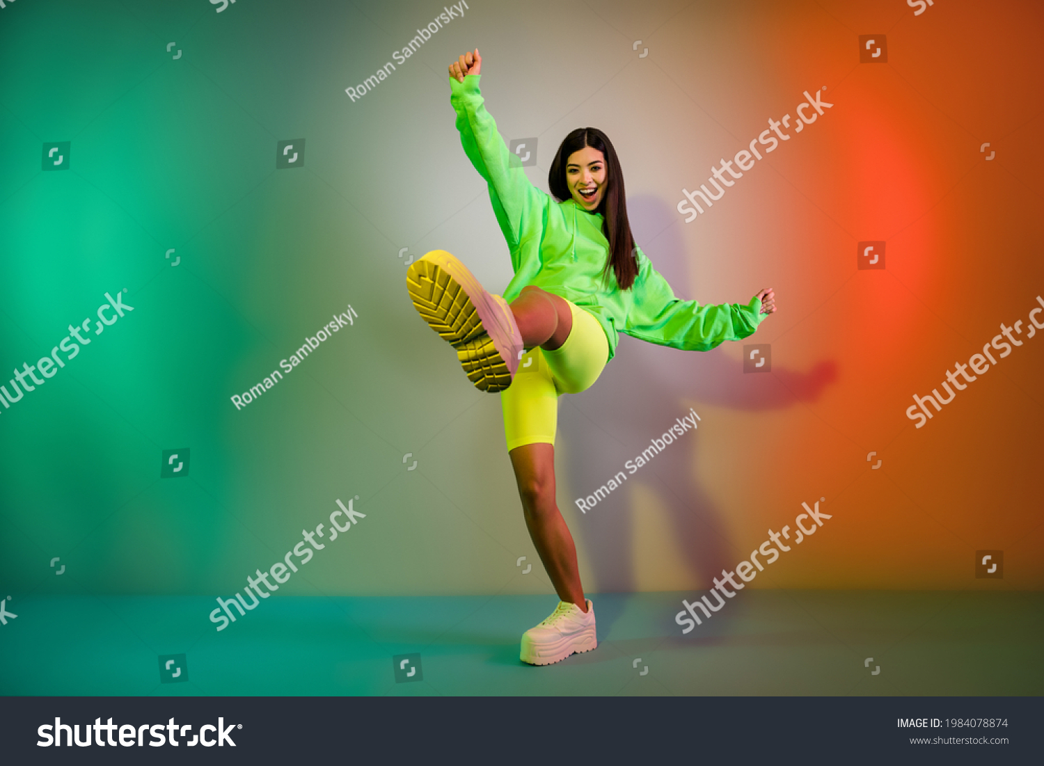 Full length body size view of pretty funky cheerful girl dancing good mood isolated over multicolor vivid neon light background Stock-foto
