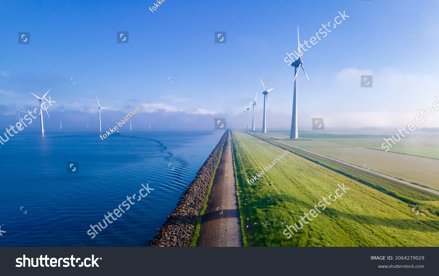 offshore windmill park with clouds and a blue sky, windmill park in the ocean aerial view with wind turbine Flevoland Netherlands Ijsselmeer. Green energy  Stock-foto